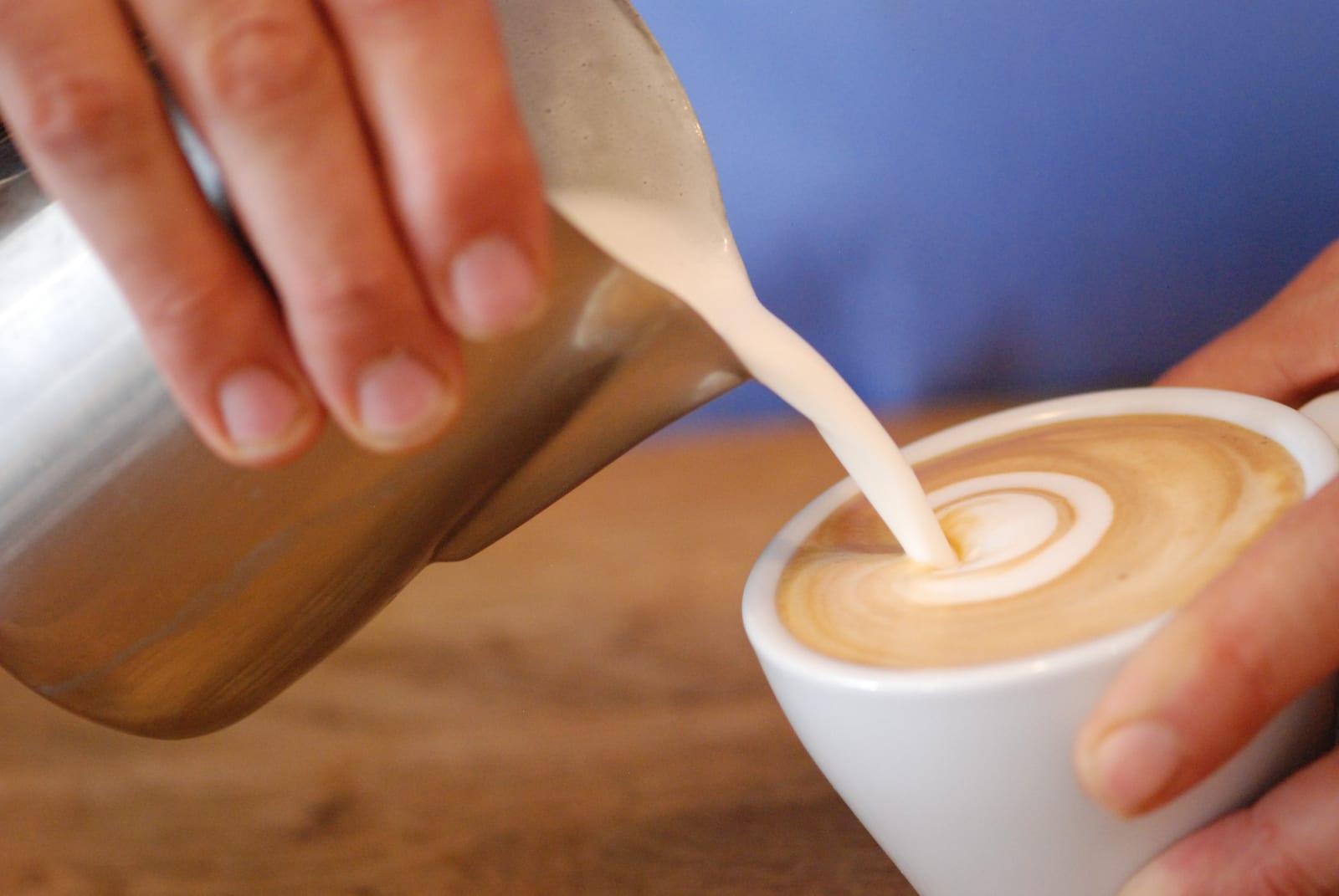 Barista pouring latte art at Arts Cafe Truro